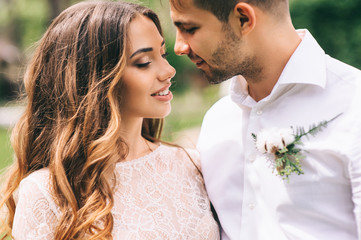 beautiful wedding couple in park. kiss and hug each other