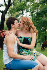 Lovers kissing and hugging on the background of horses