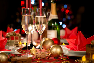 christmas eve party table with champagne flute with red and golden glitter