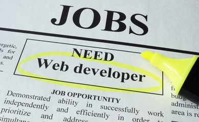 Newspaper with ads for vacancy Web developer. Employment concept.