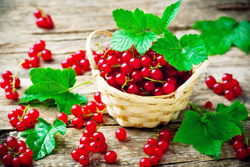 red currant in a basket on a wooden table. style rustic. selective focus