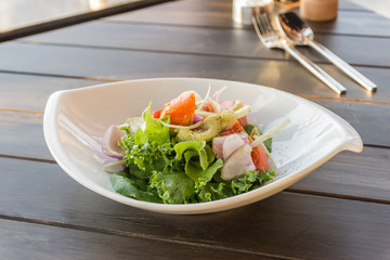 olive oil pouring into bowl of salad