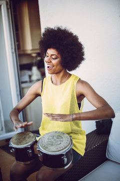 Multirracial young couple playing drums and a guitar