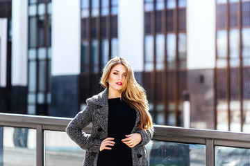 Pleasant modern attractive business young woman standing on office backgraund