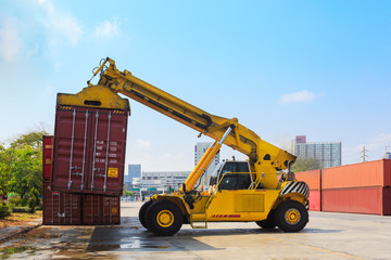 Fototapeta premium Cargo containers and folklift in shipping yard for import,export industrial