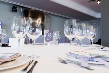 Wedding restaurant table with glasses, napkins and cutlery