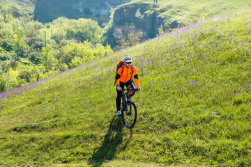 Fototapeta premium Cyclist on the Beautiful Meadow Trail