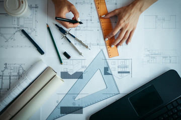 Architect drawing blueprints using technical pen
