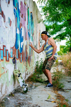 Senior Hipster Man Painting a Graffiti on a Wall with Spray
