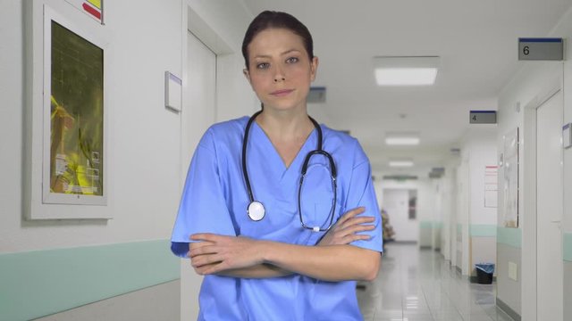 Depressed nurse crosses her arms while in the hall