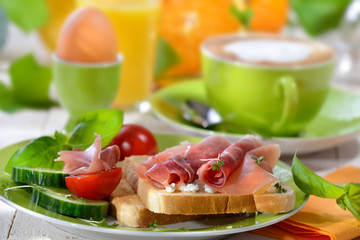 Frühstück mit Schinkentoast und Ei sowie einer Tasse Cappuccino - Breakfast with ham toast, a boiled egg and a cup of cappuccino