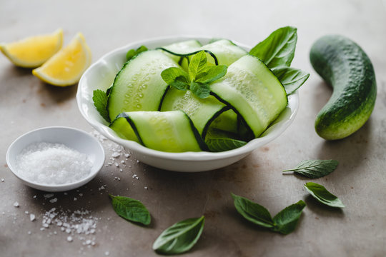 Bowl of fresh cucumber and mint salad with sea salt and lemon