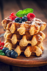 Belgian waffles with raspberries,currant,blueberries and sprinkled with sugar