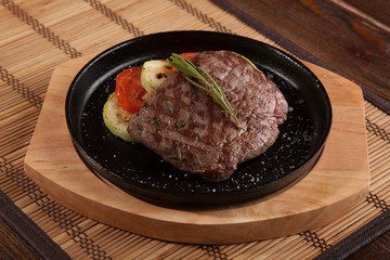 Steak flambe on black pan