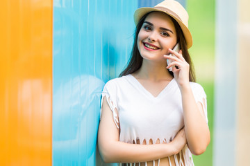 Young girl talking phone on the street over color background