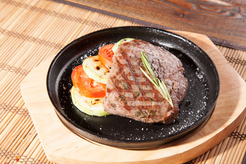 Steak flambe on black pan