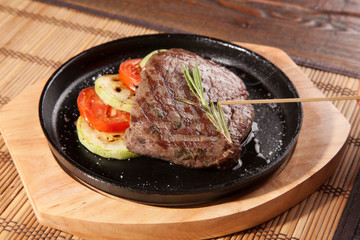 Steak flambe on black pan