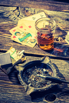Old table for illegal poker with vodka, cigarettes and cards