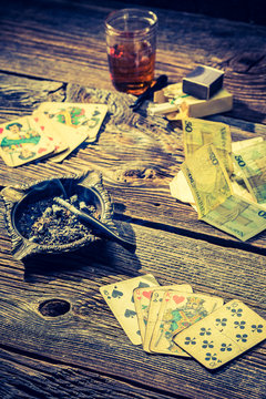 Cards and money on vintage table for illegal poker