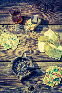 Vodka, cigarettes and cards on vintage illegal gambling table