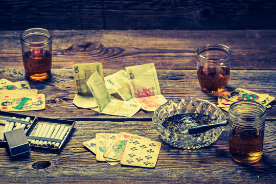 Cards and money on old table for illegal poker