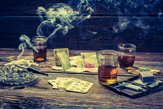 Vodka, cigarettes and cards on old illegal gambling table