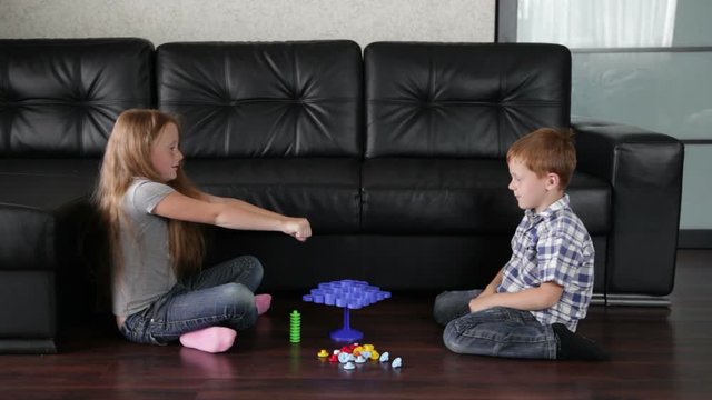 Children activity- brother and sister are playing on the floor in the living room