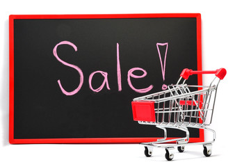 Shopping cart with chalk written word "Sale" on black board