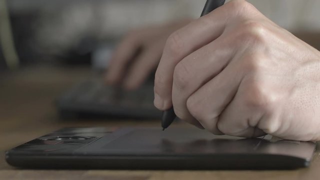 Side view man architect 3D designer uses his pen tablet with his computer