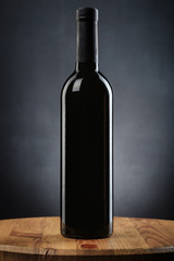 Bottle of wine on a wooden table on gray background