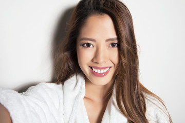 beautiful young asian woman with flawless skin and long hair posing in bath robe
