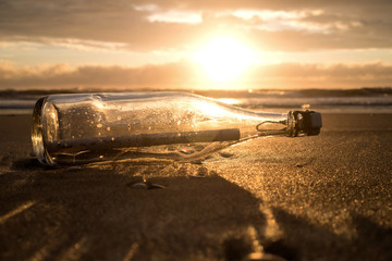 Flaschenpost am Strand bei Sonnenuntergang  - obrazy, fototapety, plakaty