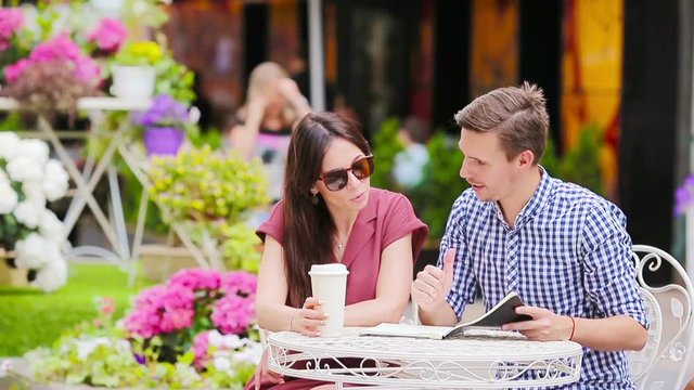 Restaurant tourists couple eating at outdoor cafe. Young woman and man enjoy time outside ay warm summer day