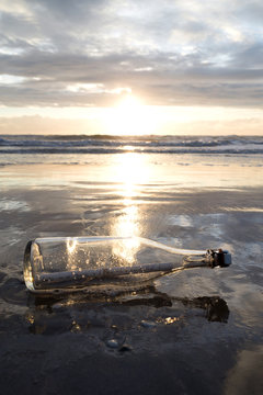 Flaschenpost am Strand bei Sonnenuntergang 
