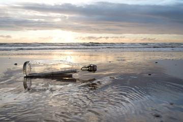 Flaschenpost am Strand bei Sonnenuntergang 