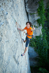 male rock climber. rock climber climbs on a rocky wall. man show ThumbUp gesture, sign.