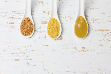 Different types of mustard: powder, seeds, spicy cream. Top view