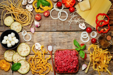 Pasta tomato basil eggplant meat minced onion wood background