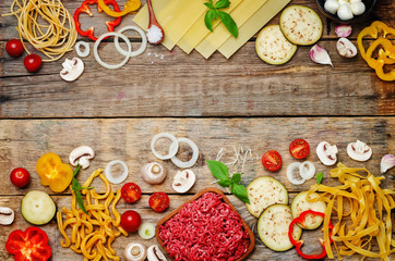 Pasta tomato basil eggplant meat minced onion wood background