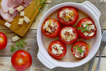 Baked stuffed tomatoes with bacon and feta cheese on the table i