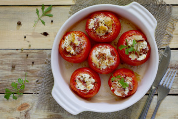 Baked stuffed tomatoes with bacon and feta cheese on the table i