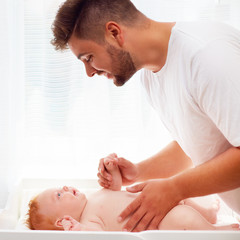 happy father taking care of infant baby © Olesia Bilkei
