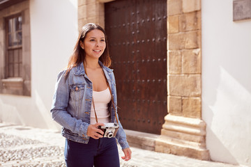 Young girl strolling with a camera