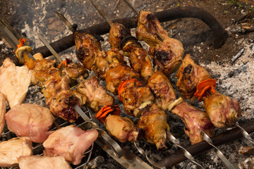 Assorted meat from chicken and pork and various vegetables on barbecue grill cooked for summer family dinner