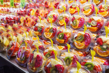 Fototapeta na wymiar Fruit Salad arranged in plastic cups on a market