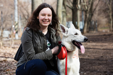 Woman playing with white Swiss shepherd dog