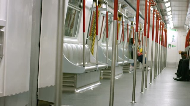 Sparklingly clean, and nearly empty interior of a subway commuter train car, with modular seating and safety handrails. Video 1920x1080