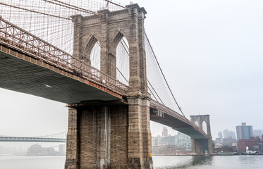 Obraz premium Brooklyn Bridge with Fog in the background over Manhattan City