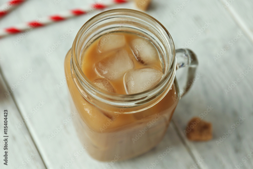 Wall mural Iced coffee with milk on wooden background