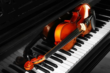 Violin lying on piano keys, close up